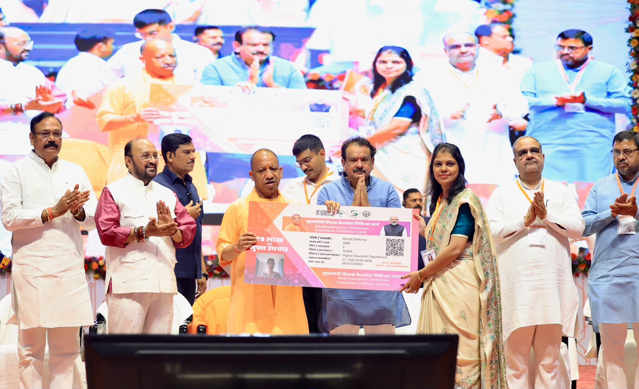 UP CM Yogi launching the Teacher Cashless Medical Scheme at an event in Agra with education officials and beneficiaries.